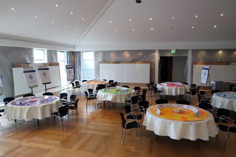 Tische mit vorgemalten Unterlagen für das Format World Cafe