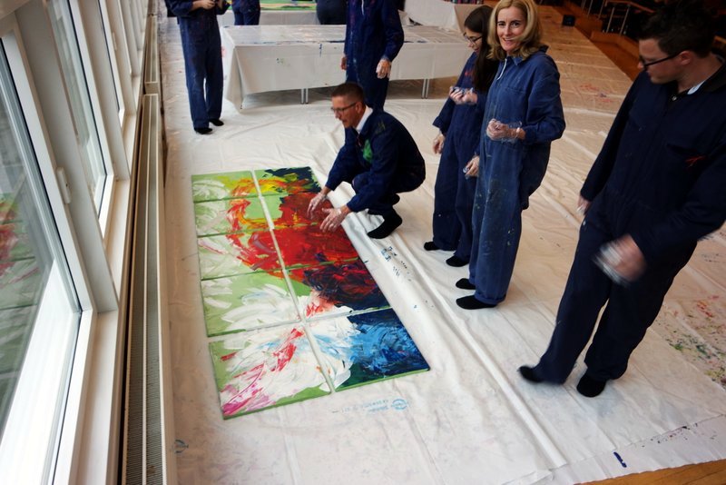 MitarbeiterInnen von Daimler Logistics malen gemeinsam während einer kreativen Teambuilding Aktion ihre neuen Kulturelemente