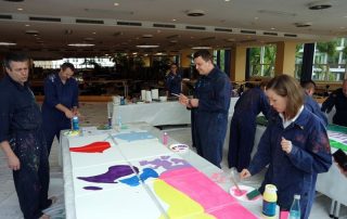 MitarbeiterInnen von Daimler Logistics malen gemeinsam während einer kreativen Teambuilding Aktion ihre neuen Kulturelemente