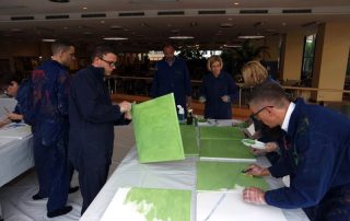 MitarbeiterInnen von Daimler Logistics malen gemeinsam während einer kreativen Teambuilding Aktion ihre neuen Kulturelemente