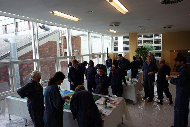 MitarbeiterInnen von Daimler Logistics malen gemeinsam während einer kreativen Teambuilding Aktion ihre neuen Kulturelemente