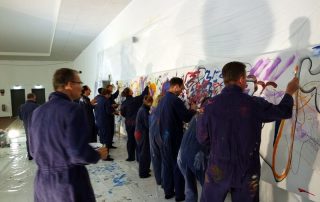 MitarbeiterInnen malen ein Teampainting